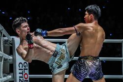 Dua atlet kickboxing bertukar serangan.jpg